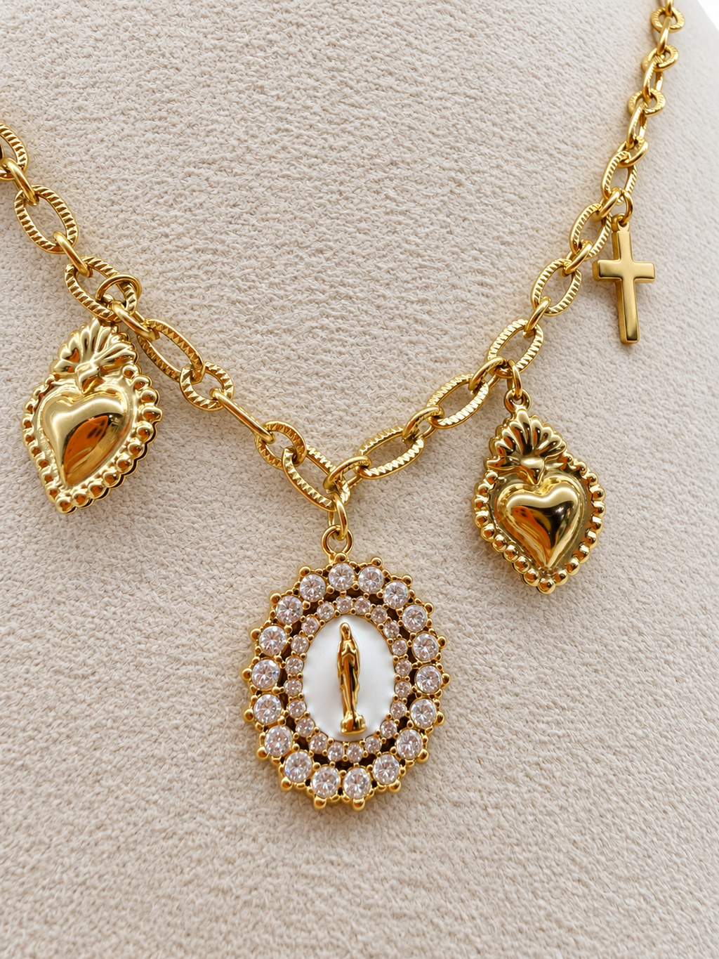 Collier doré à breloques croix, cœurs et médaille de la madone