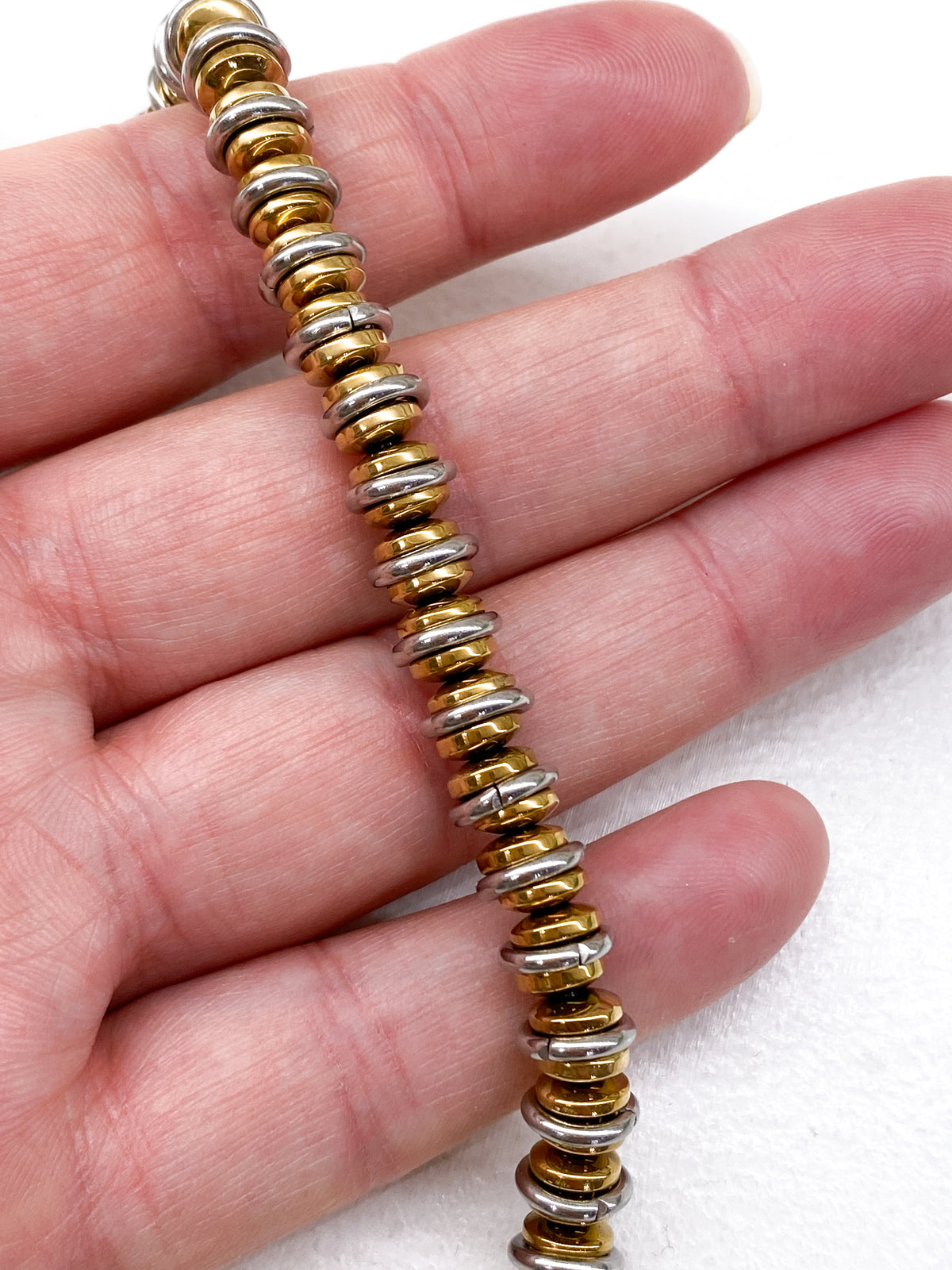 Bracelet en acier inoxydable avec rondelles dorées et anneaux argentés