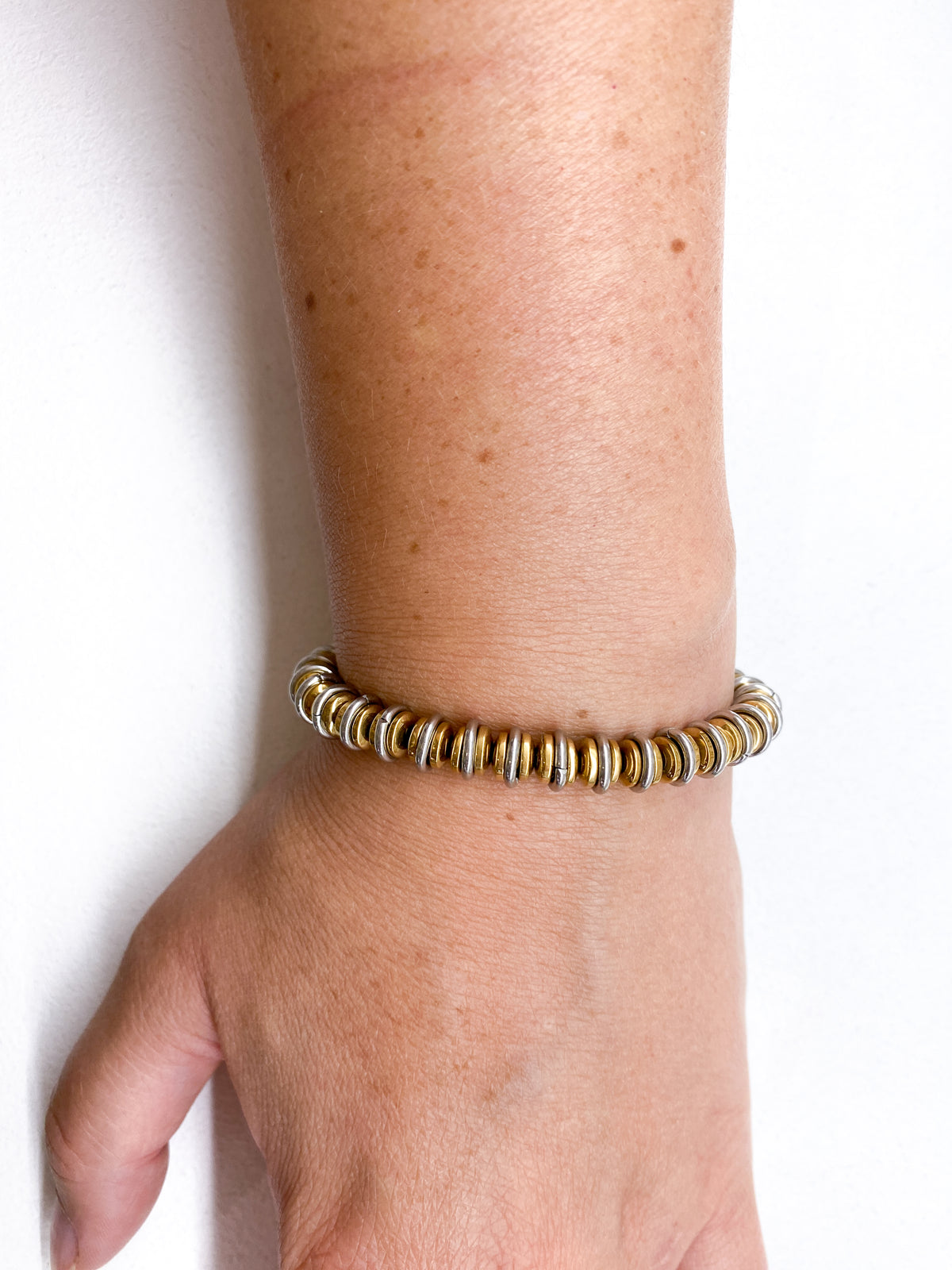 Bracelet en acier inoxydable avec rondelles dorées et anneaux argentés