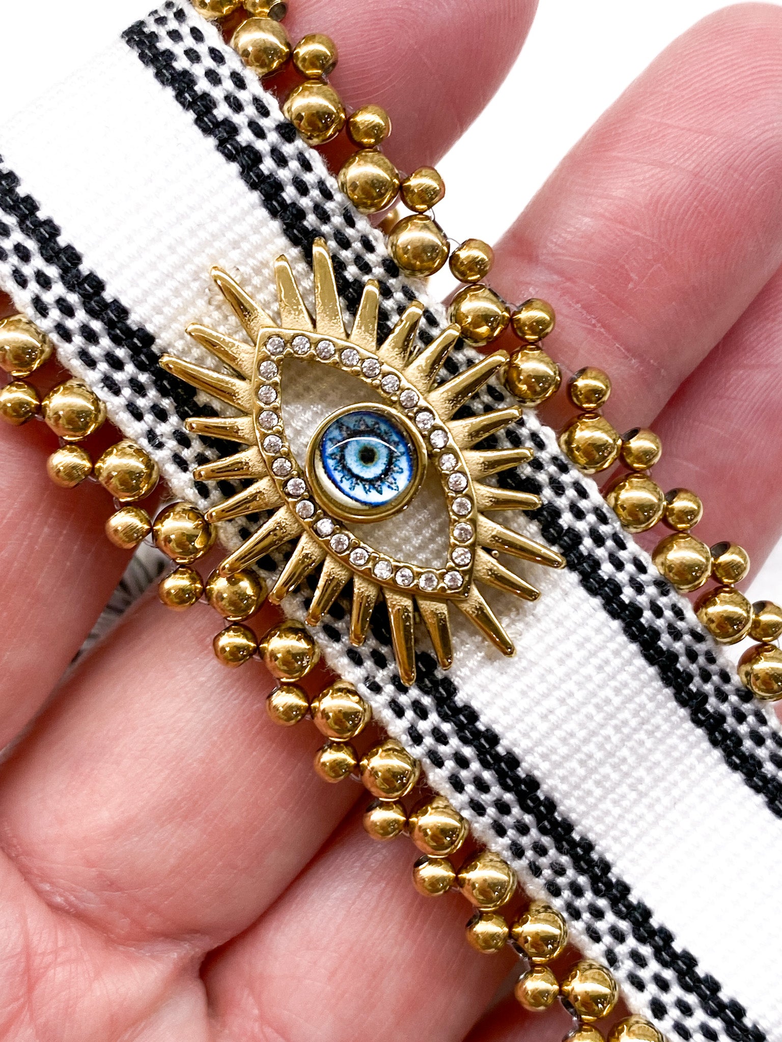 Bracelet femme large tressé avec œil grec et perles dorées