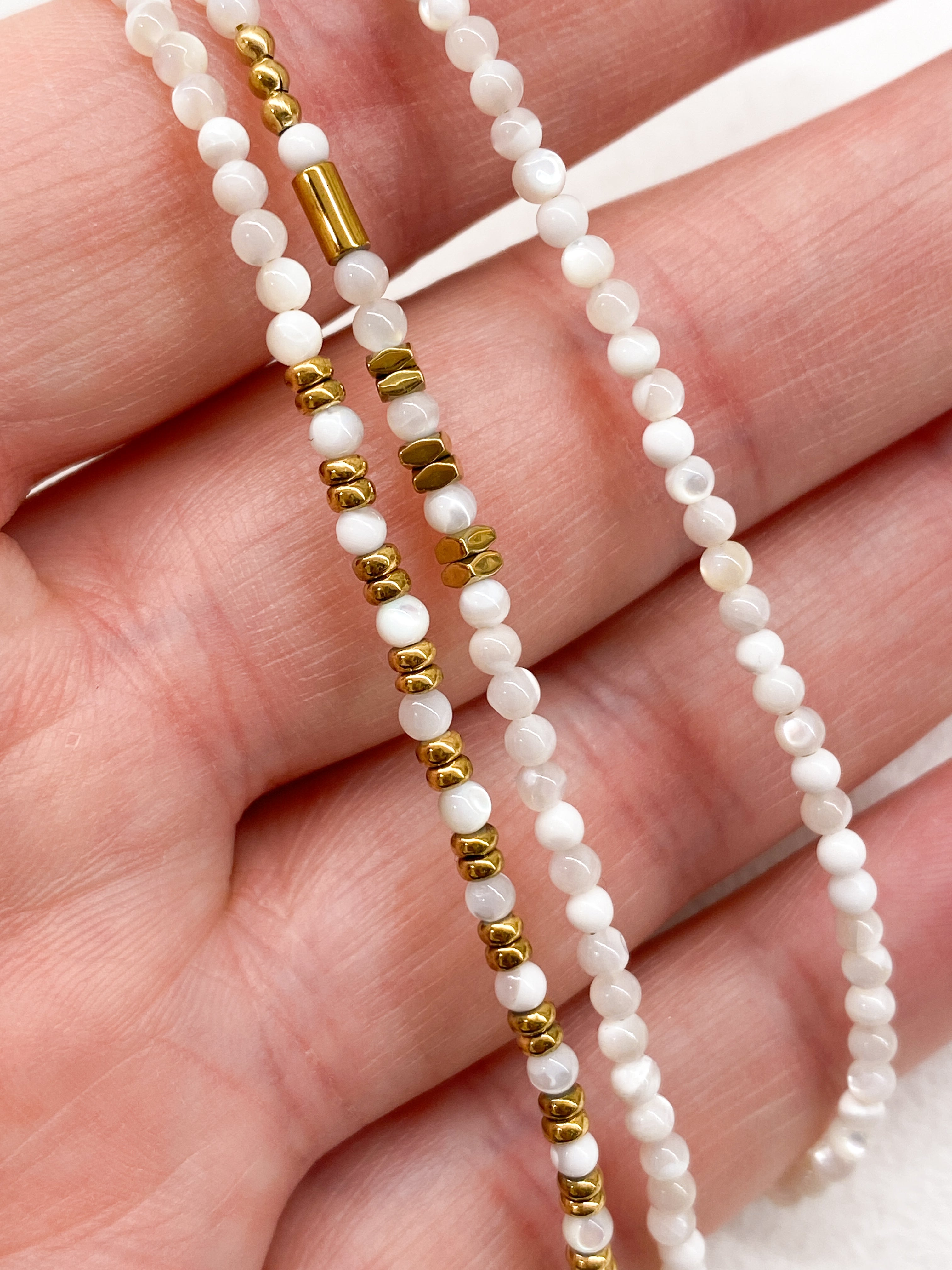 Bracelet blanc multi-rangs avec éléments géométriques