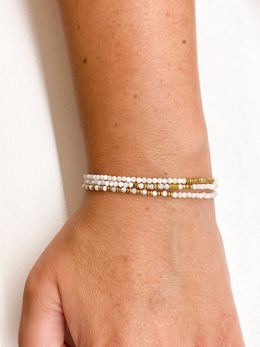 Bracelet blanc multi-rangs avec éléments géométriques