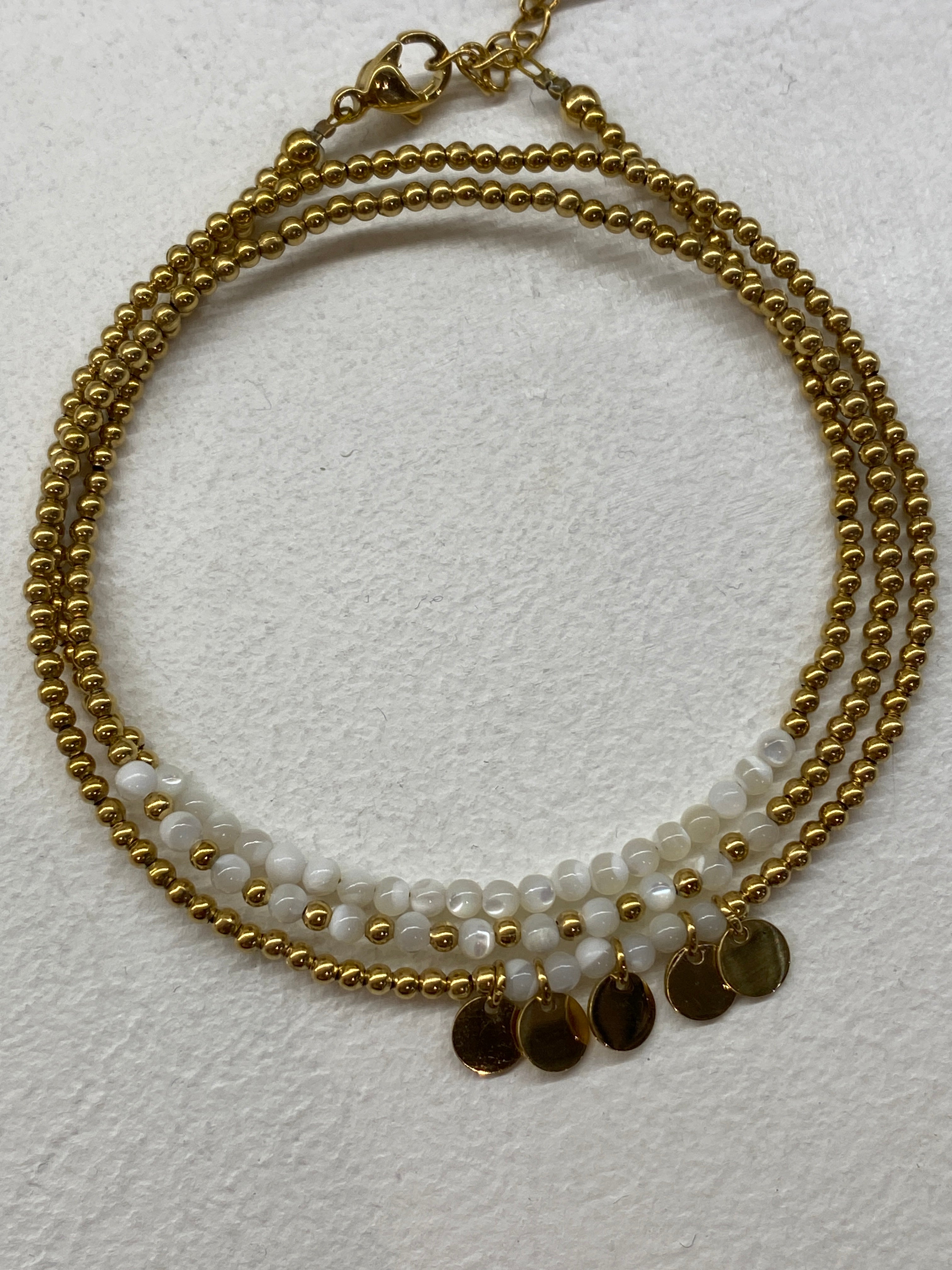 Bracelet multi-rangs blanc avec médaillons dorés