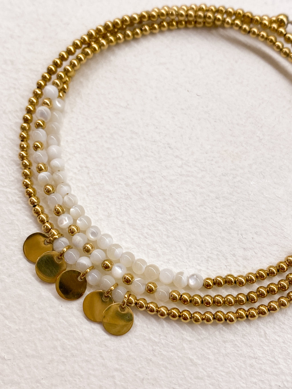 Bracelet multi-rangs blanc avec médaillons dorés