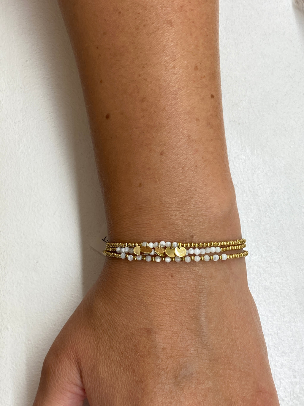 Bracelet multi-rangs blanc avec médaillons dorés