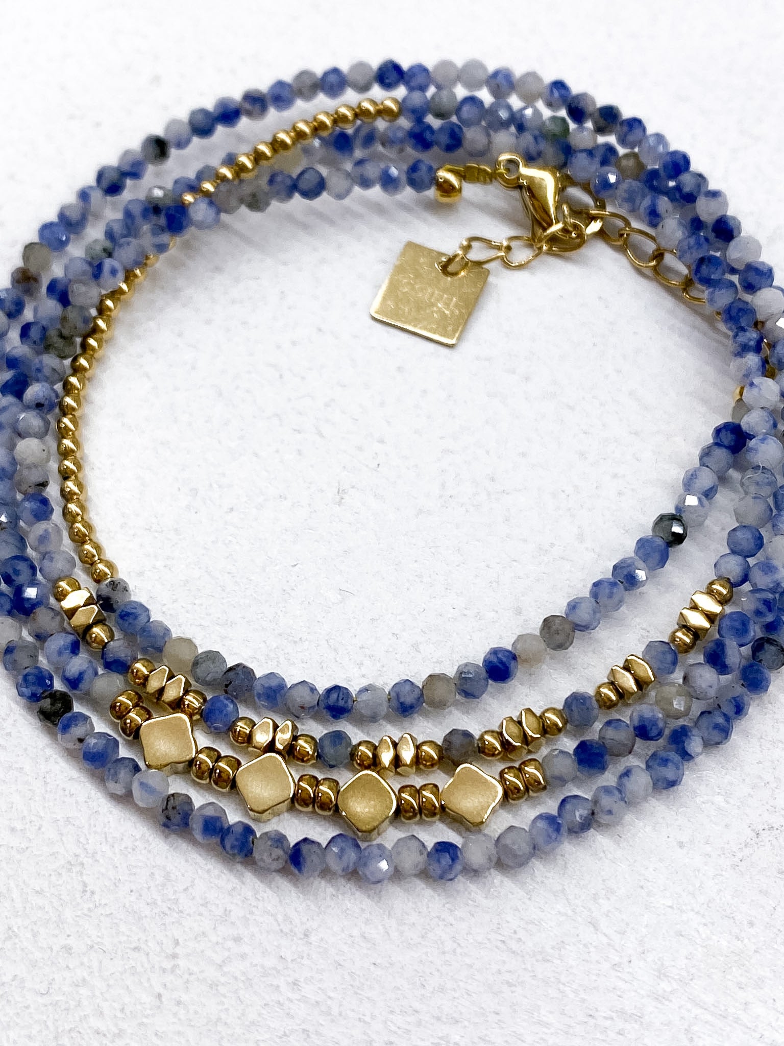 Bracelet à 4 rangs avec détails géométriques en acier inoxydable doré