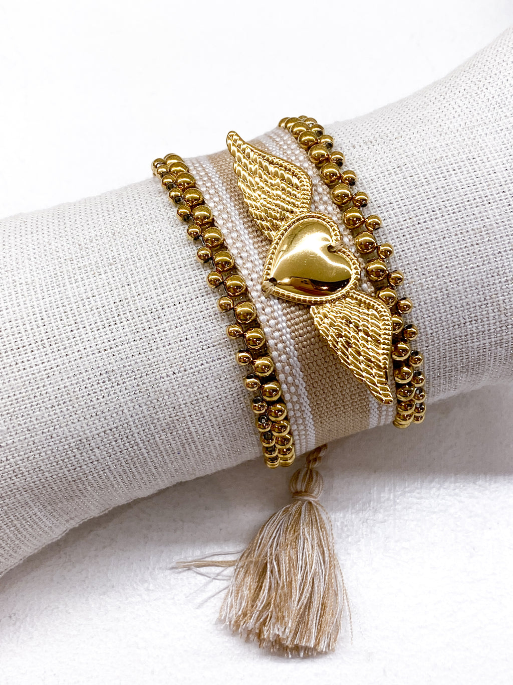Bracelet large tissé coulissant avec perles dorées et cœur ailé