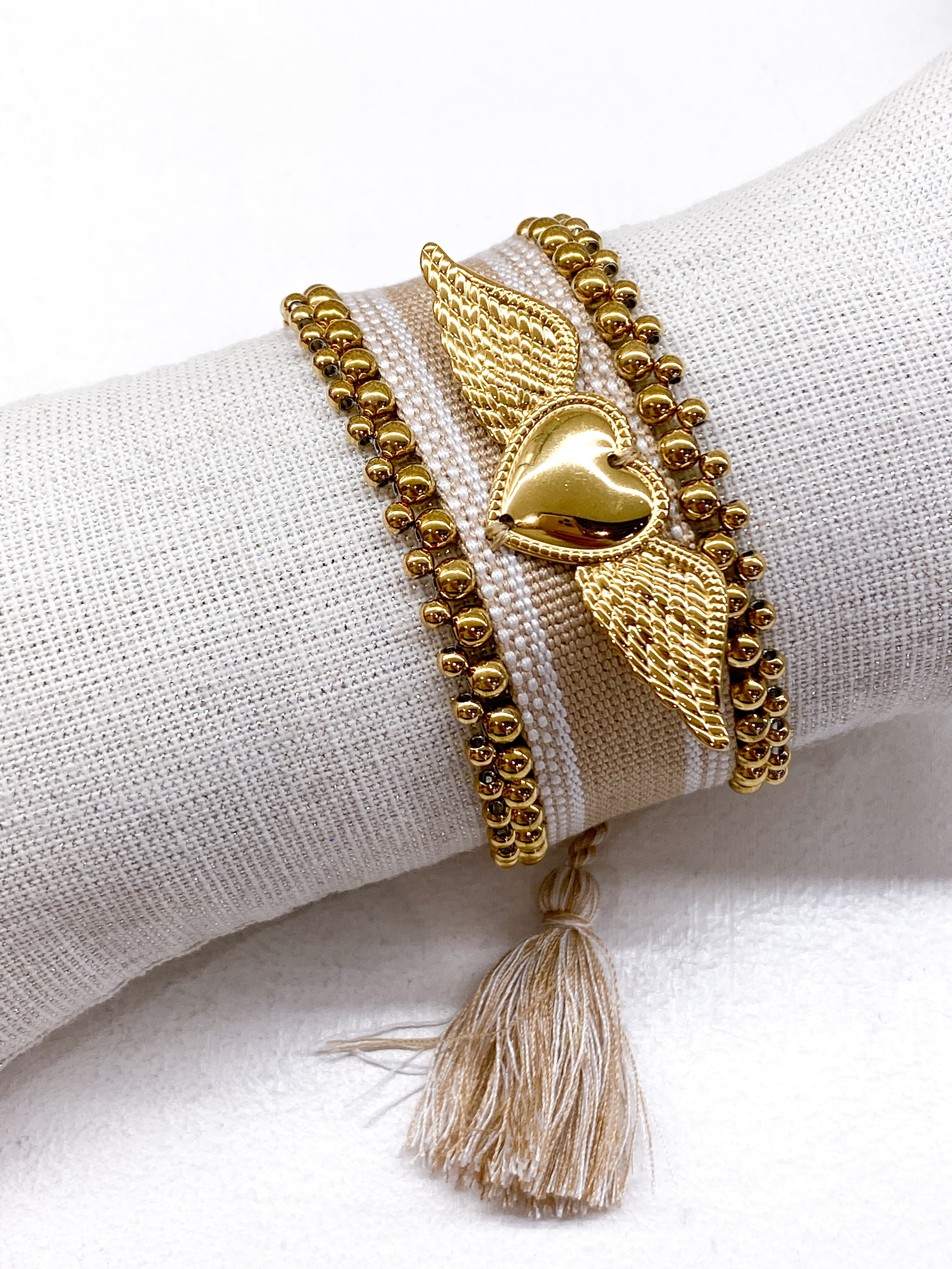 Bracelet large tissé coulissant avec perles dorées et cœur ailé