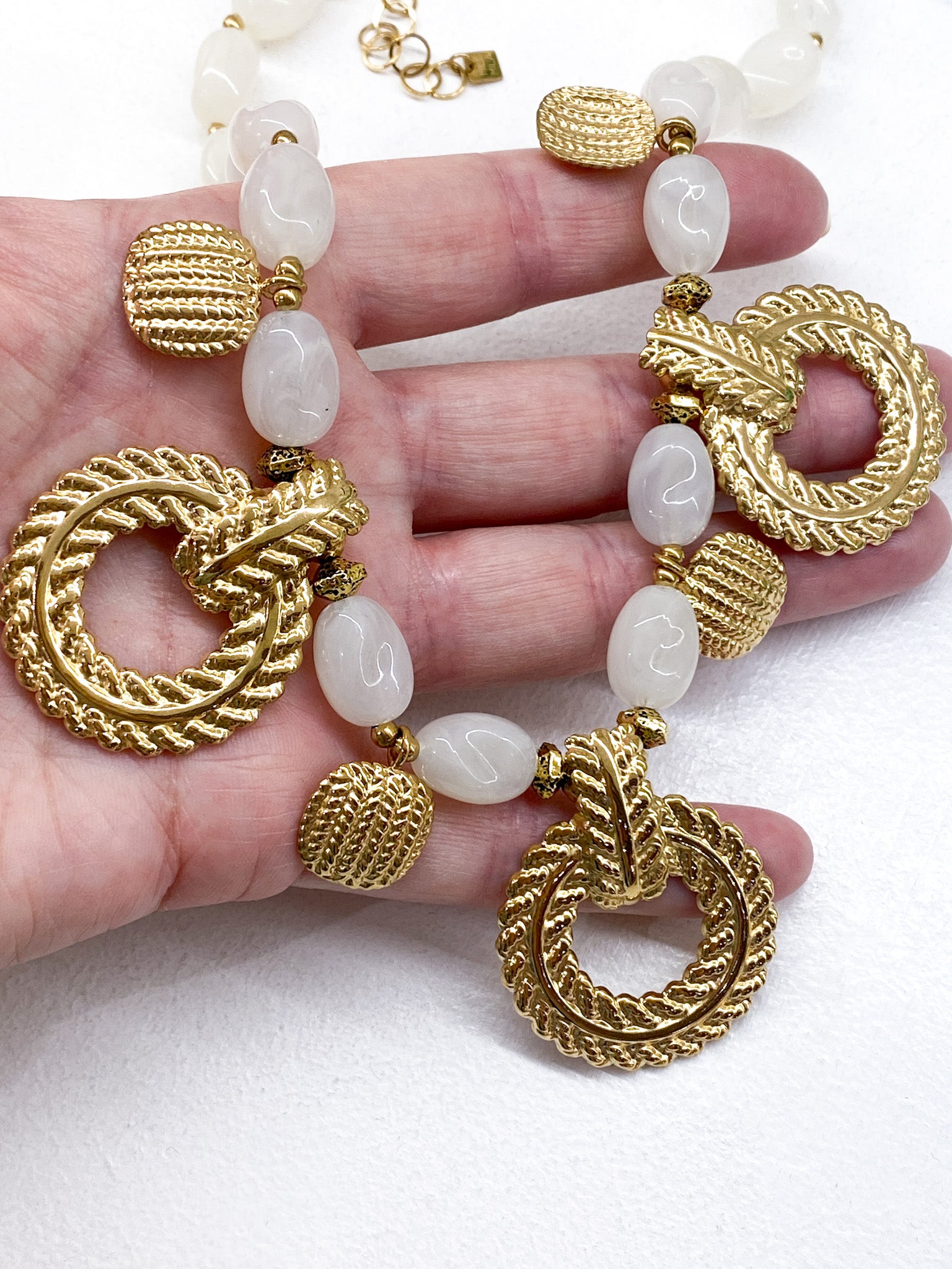 Collier perles ovales en acétate beige et médaillons martelés