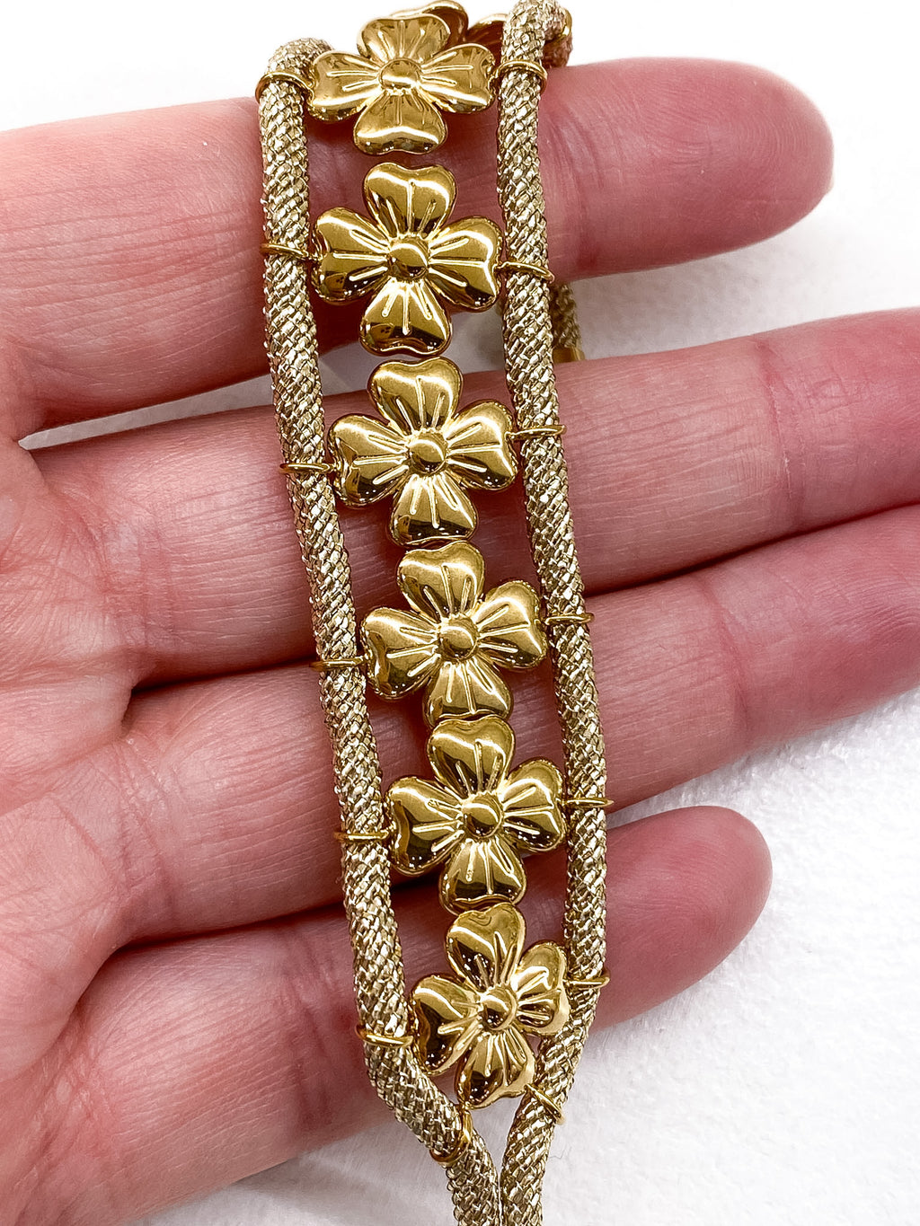 Bracelet large doré fleurs et cordons tressés